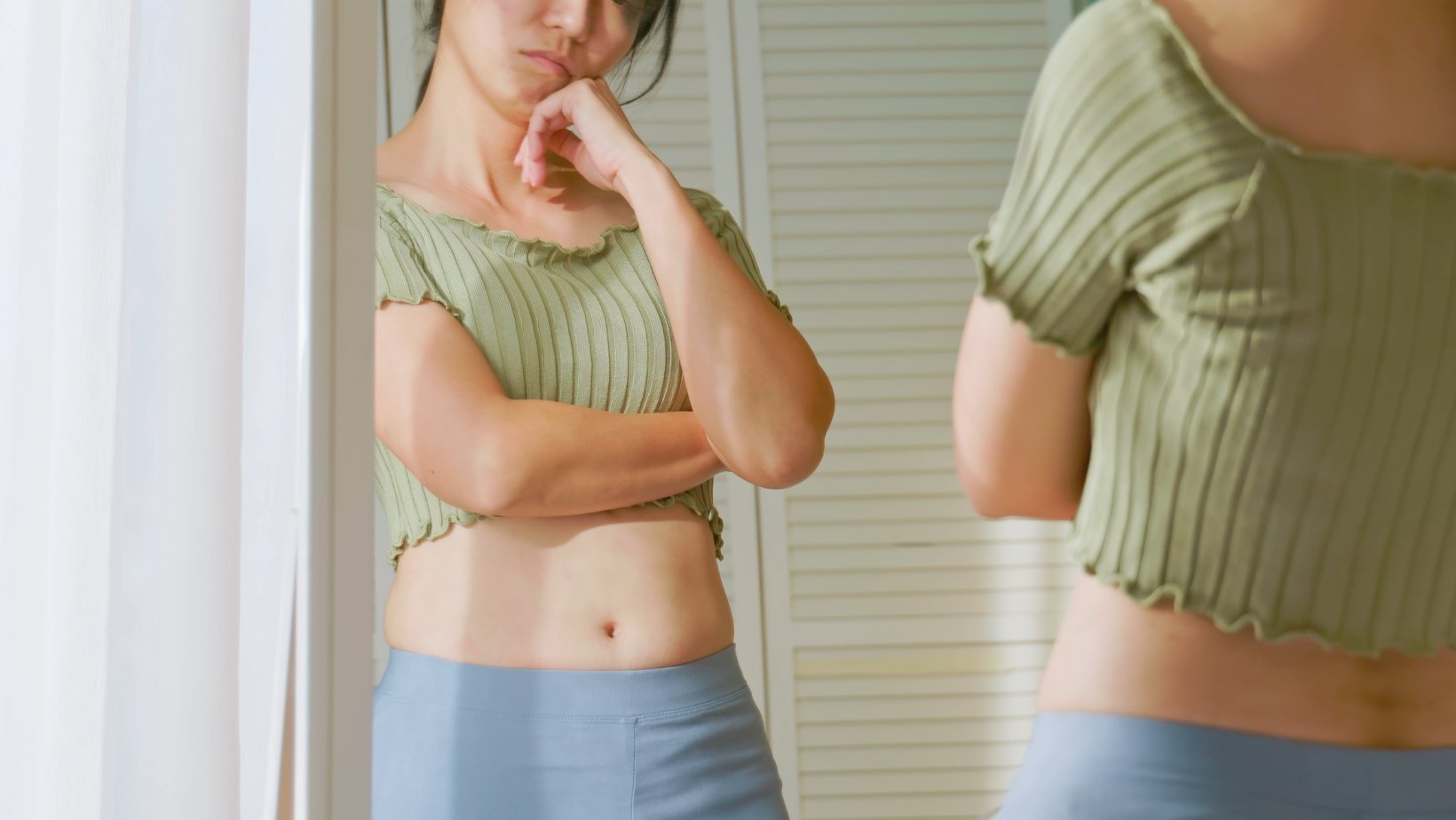 Frustrated woman looking in mirror